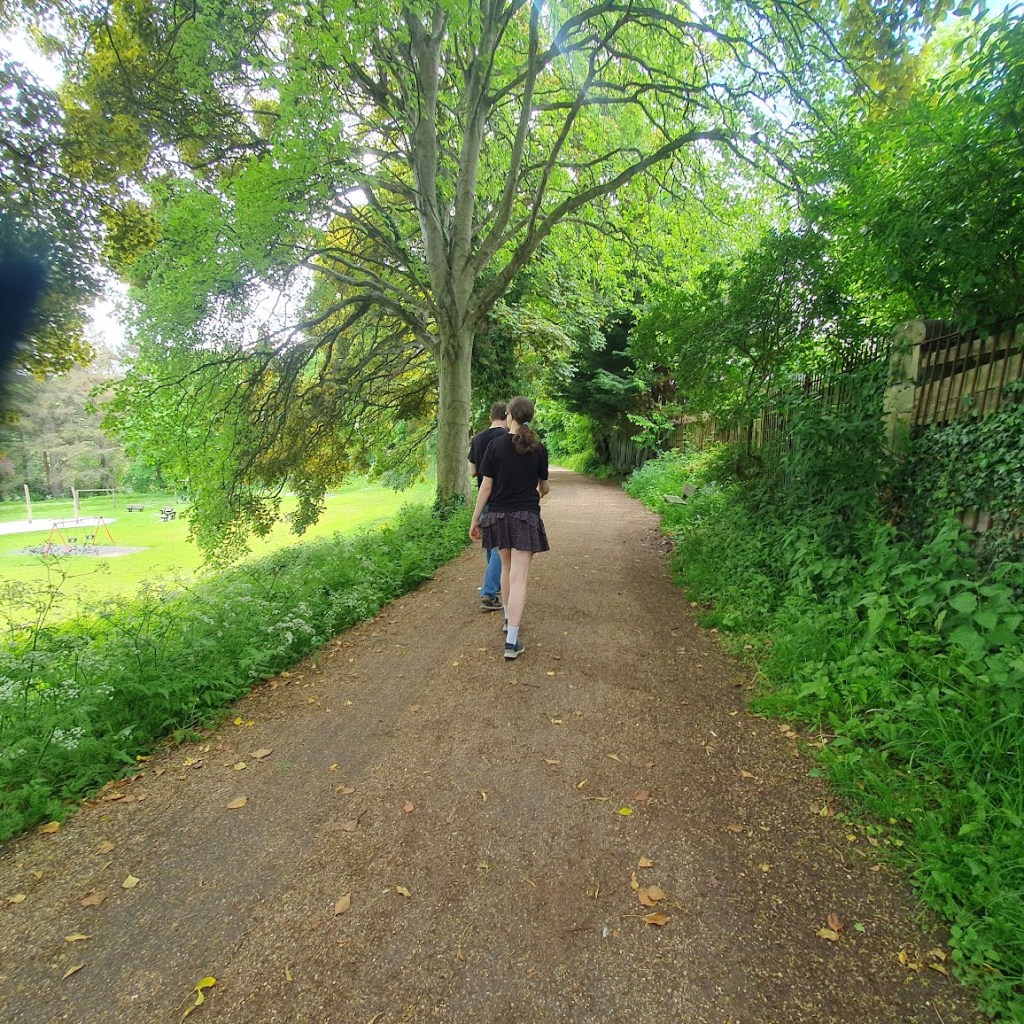Elizabeth and Daniel walking ahead on the leafy path