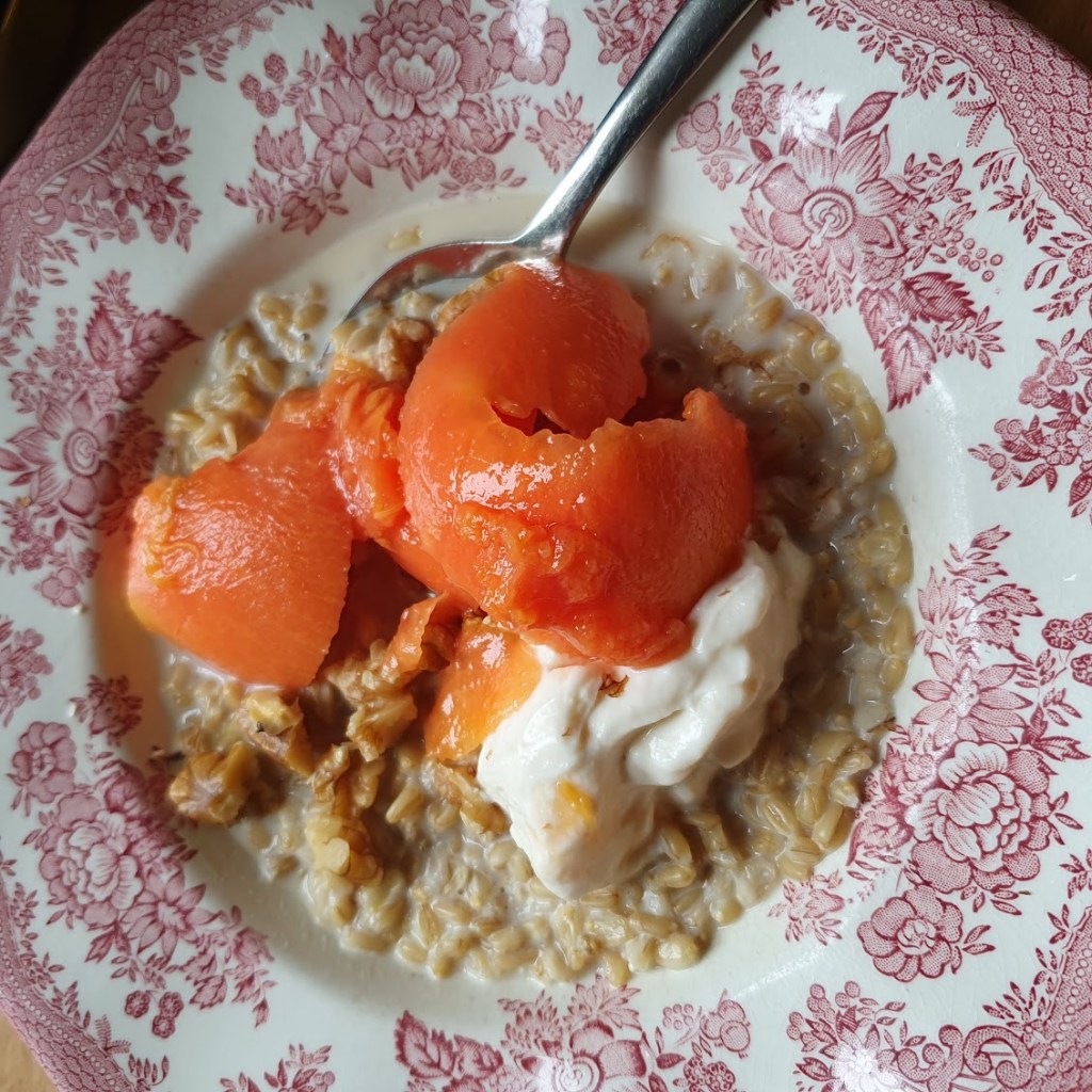A bowl of oat groats with walnuts and papaya