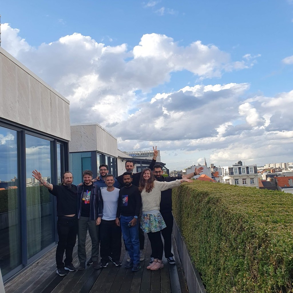 All of us on the balcony with the city skyline behind us and a clear blue sky