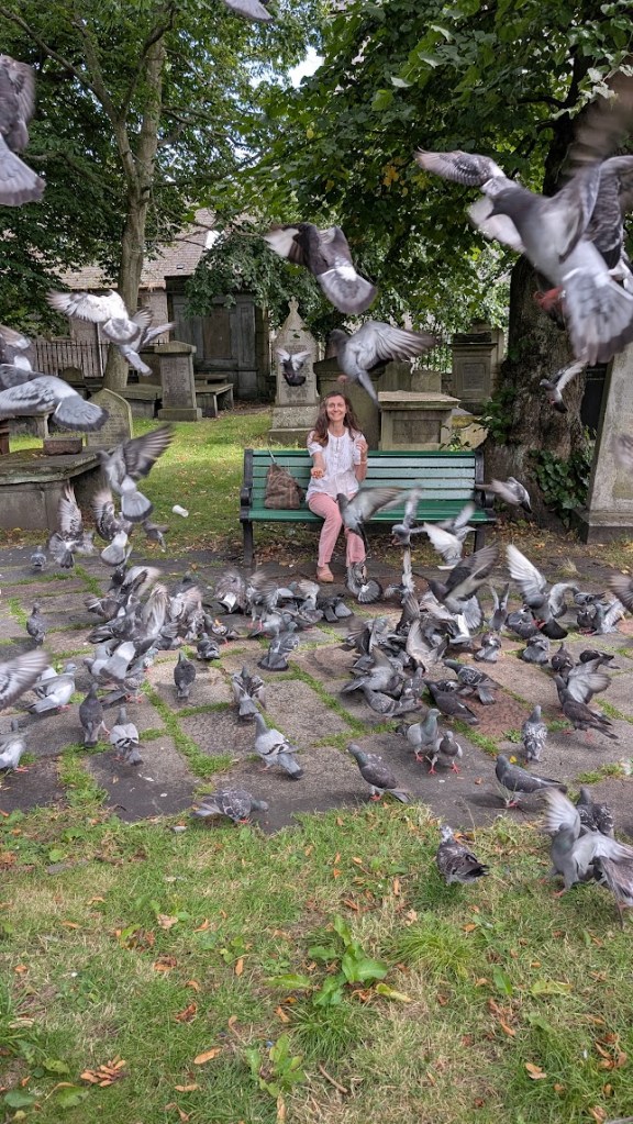 Me holding up seed surrounded by pigeons