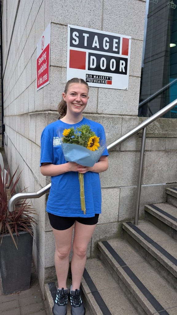 Elizabeth holding flowers at the stage door