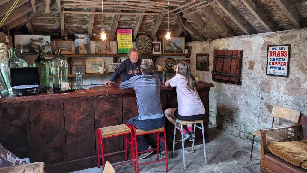 Elizabeth and Daniel sitting at the bar with Ben behind it.
