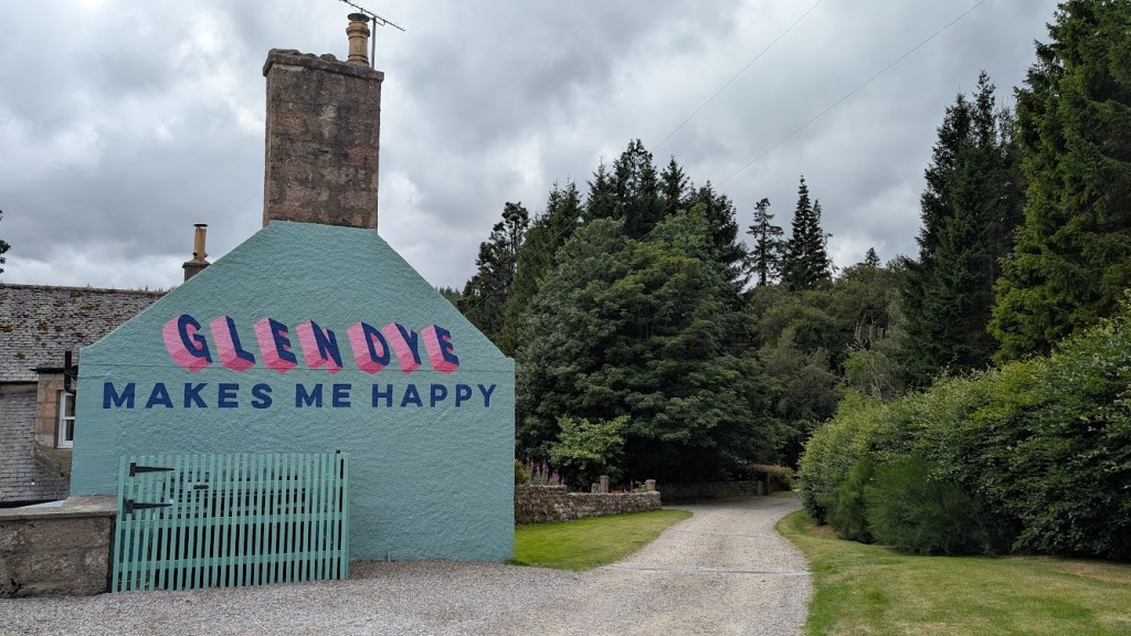 A building at Glendye with painting on the side saying "Glendye makes me happy"