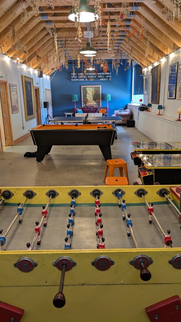 The Clubhouse with the football table in the foreground and arcade games then a pool table and table tennis.