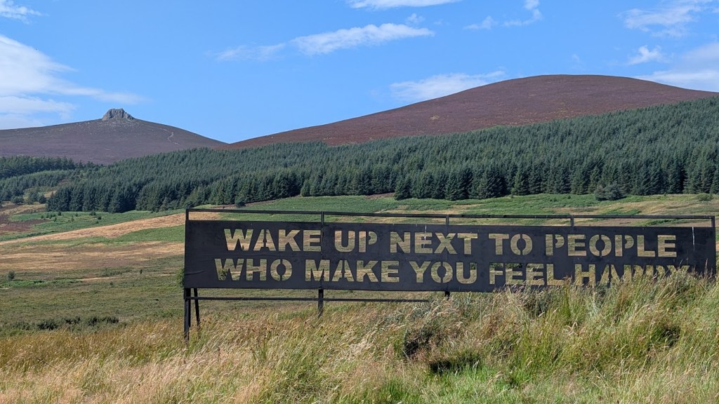 Clachnaben and the sign in the foreground, Wake up next to people who make you happy.