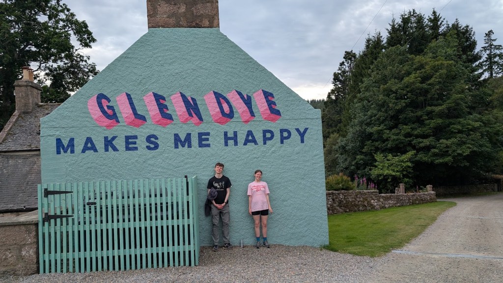 The coach house which has been painted on one side and reads, "Glendye makes me happy"